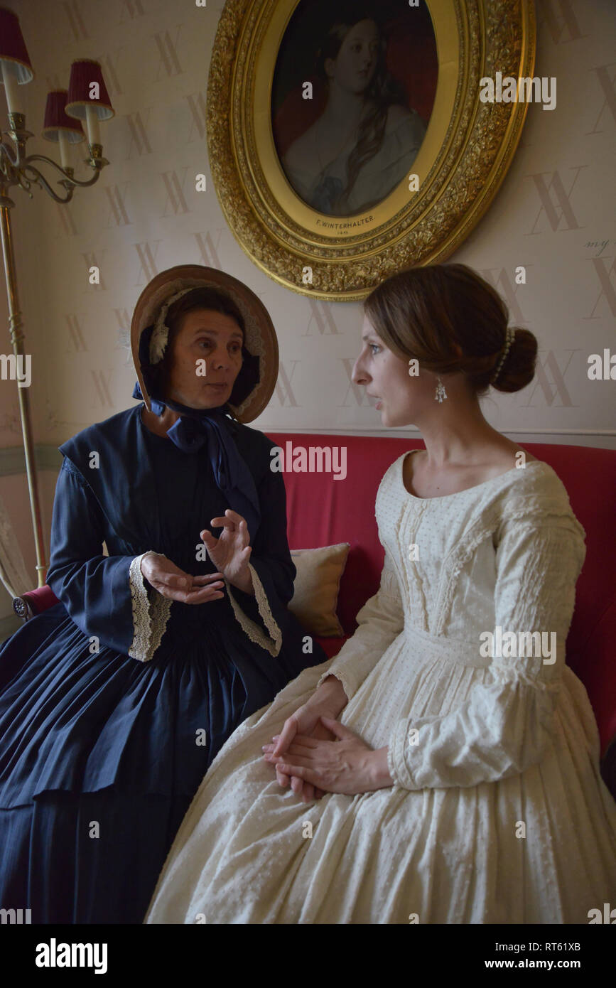 Two Women in Victorian dresses sit and chat in a formal parlour at  Kensington Place. One is a young Queen Victoria and the other is Baroness  Lehzen Stock Photo - Alamy