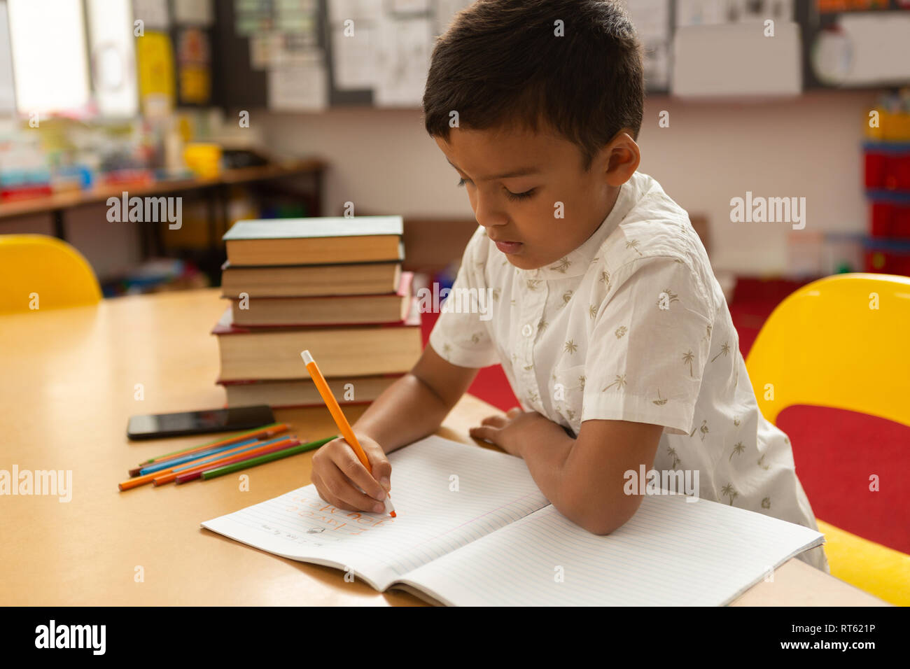 Schoolboy studying at desk in a classroom Stock Photo - Alamy