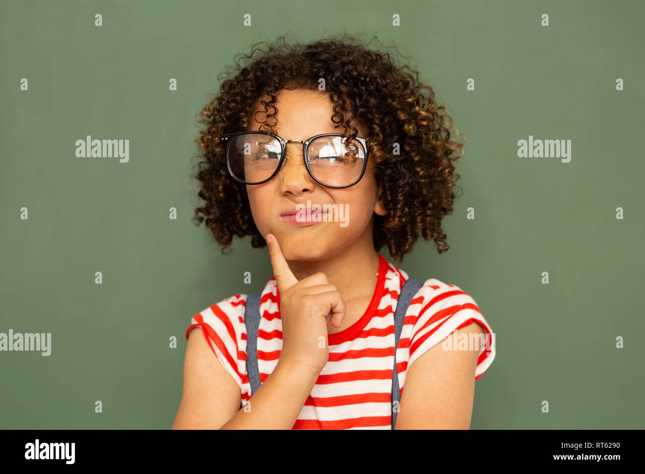 Schoolgirl standing against green board in a classroom at school Stock ...