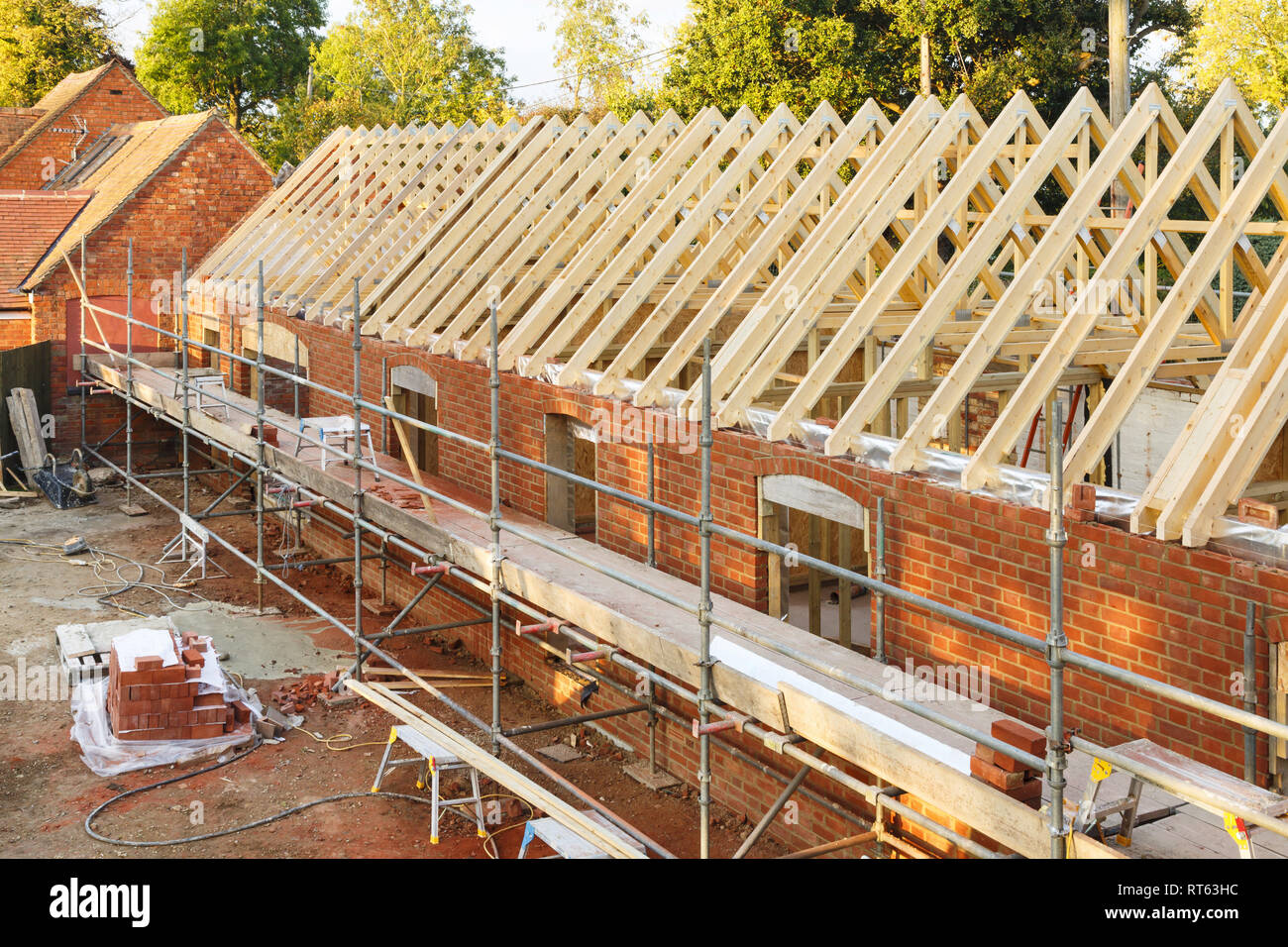 UK building site with scaffolding. Part of a period house is restored using modern building methods. Stock Photo