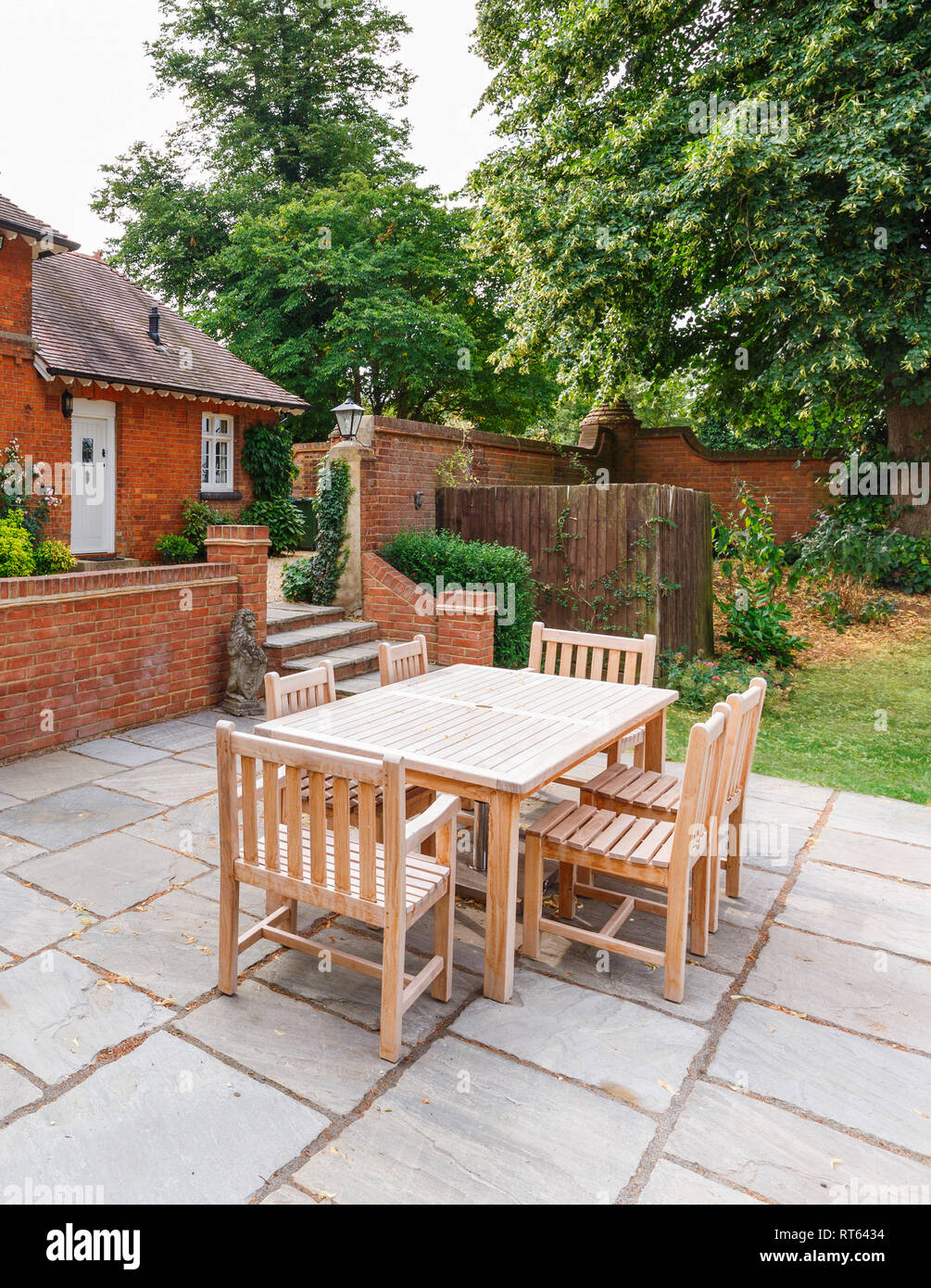 English garden and patio with wooden furniture outside a Victorian house in Buckinghamshire, UK Stock Photo
