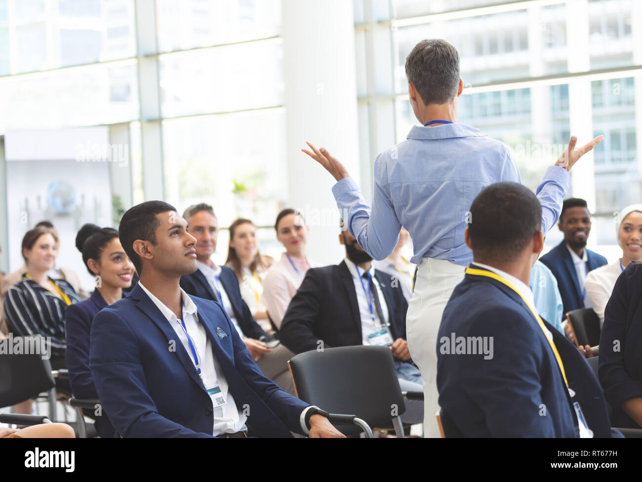Businesswoman asking question during seminar Stock Photo