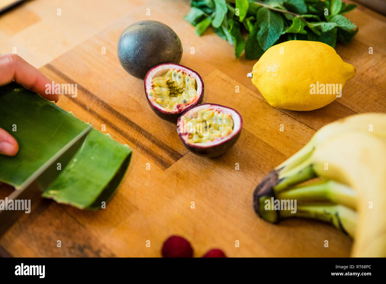Person preparing healthy fruit, slicing paaion fruits and aloe vera Stock Photo