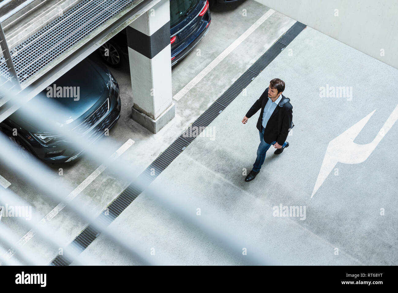 Businessman walking in parking garage Stock Photo