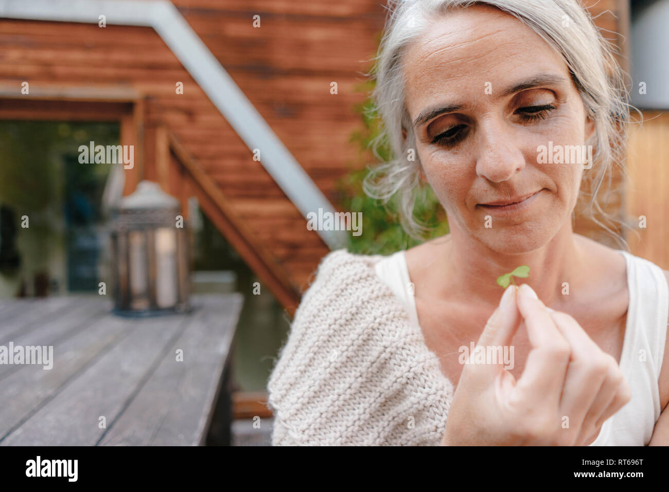 Portrait of woman looking at cloverleaf Stock Photo