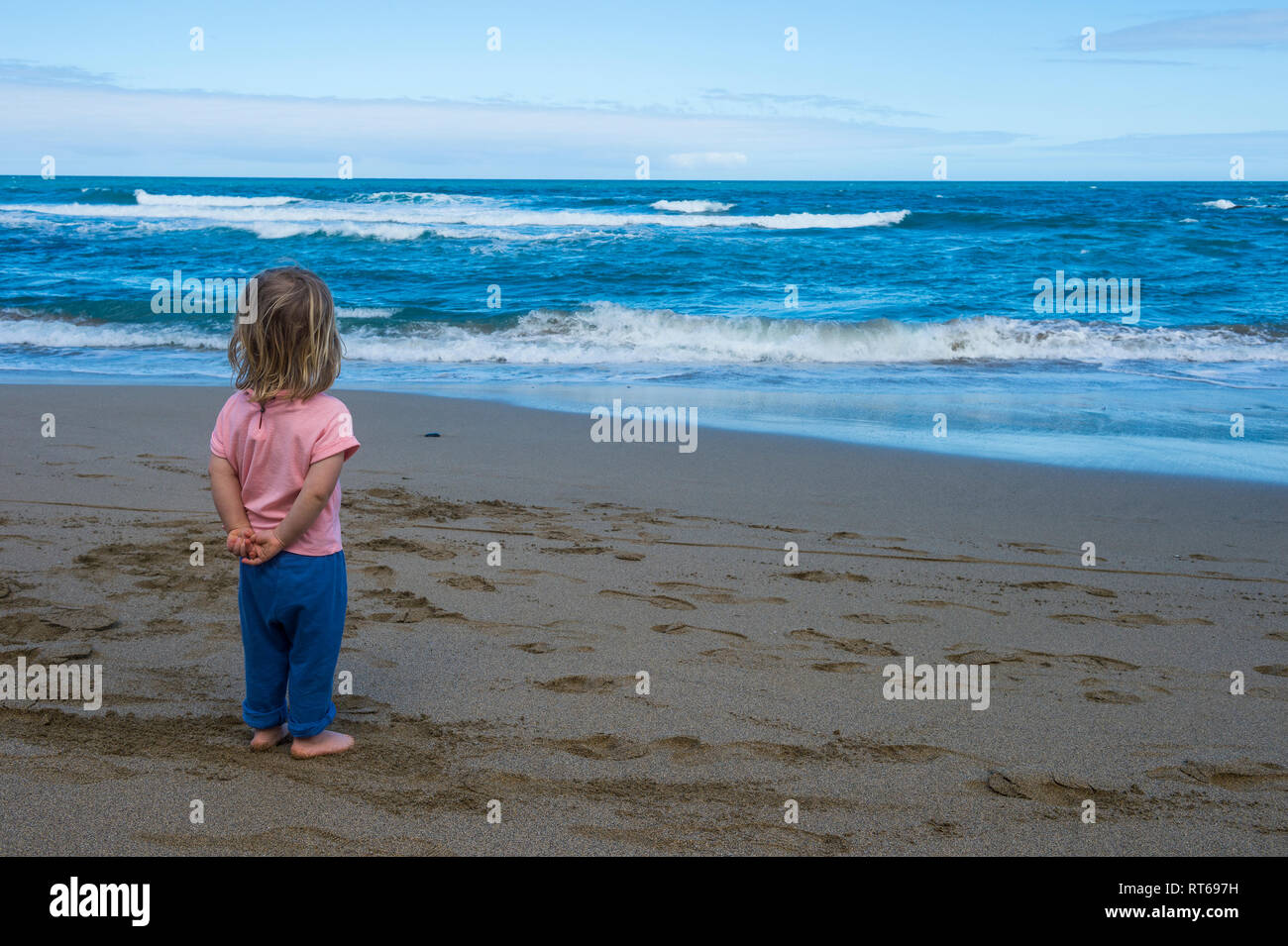 Spain, Canary Islands, Fuerteventura, La Pared, Playa del Viejo Rey, little girl standing on the beach Stock Photo