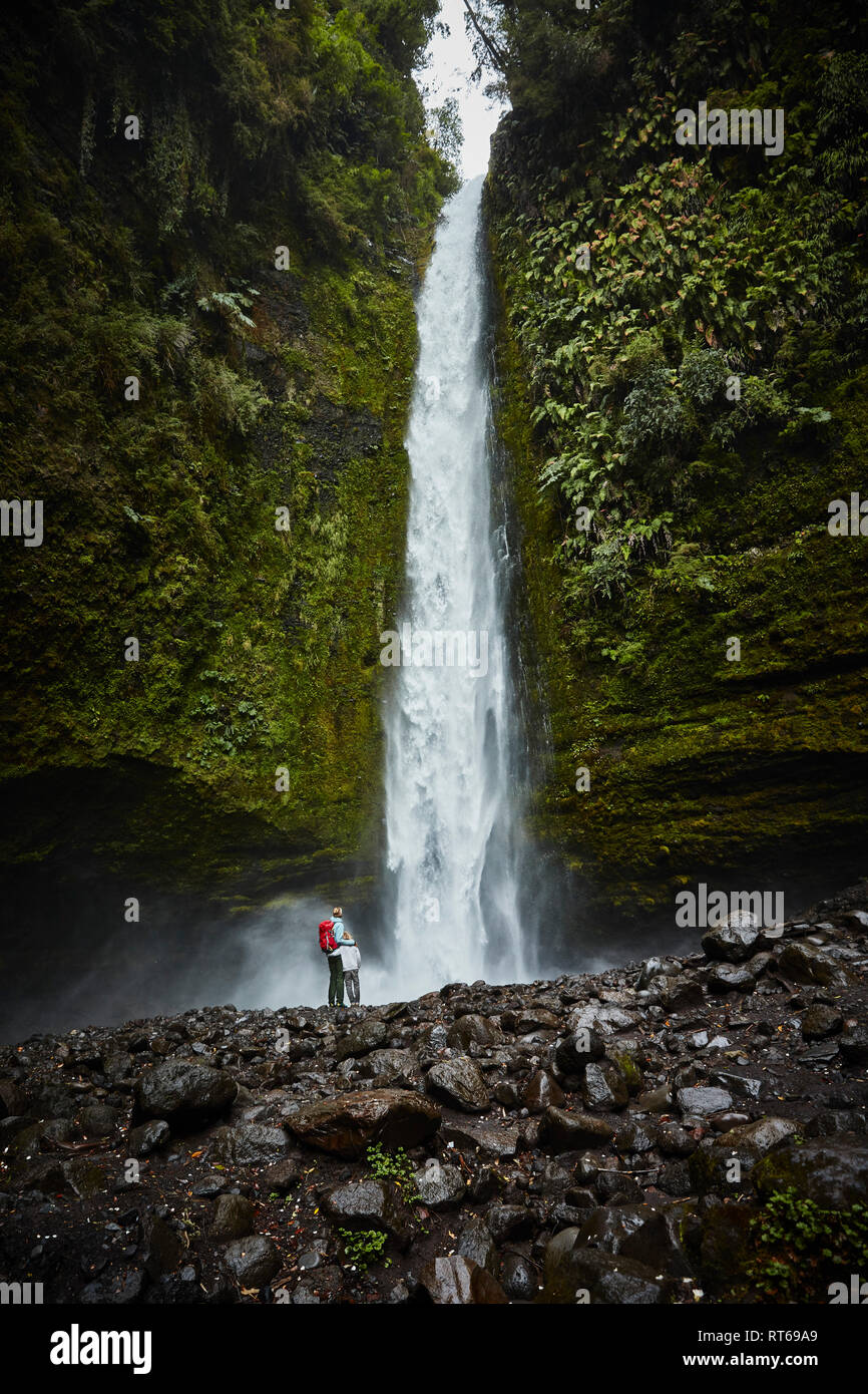 Chile, Patagonia, Osorno Volcano, mother and son standing at Las Cascadas waterfall Stock Photo