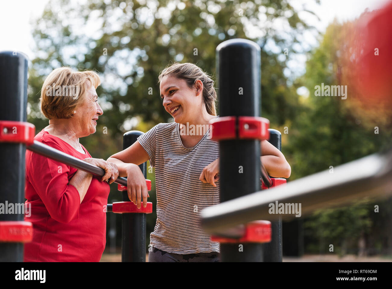 Grandmother and granddaughter training on bars in a park Stock Photo