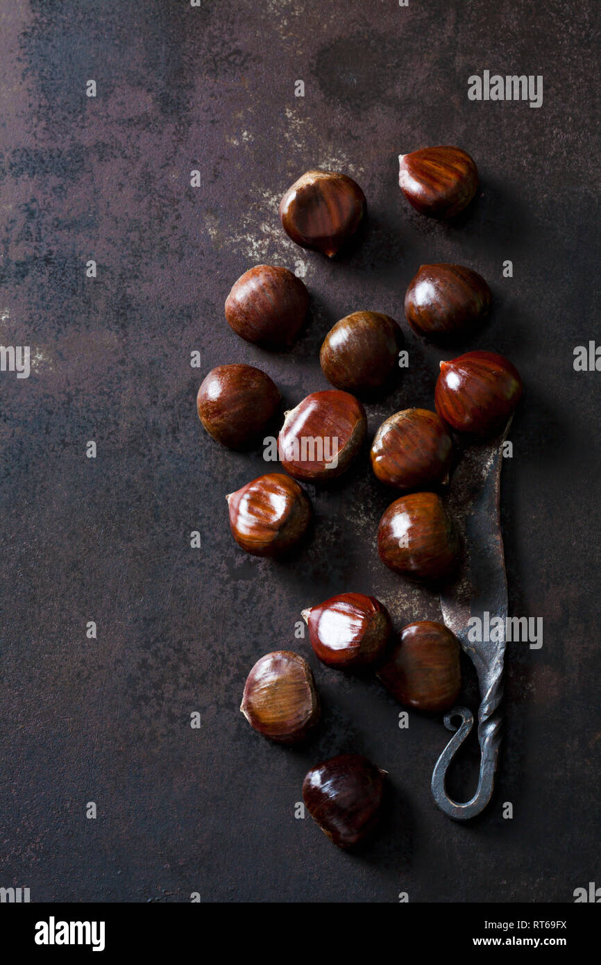 Sweet chestnuts and old knife on rusty ground Stock Photo