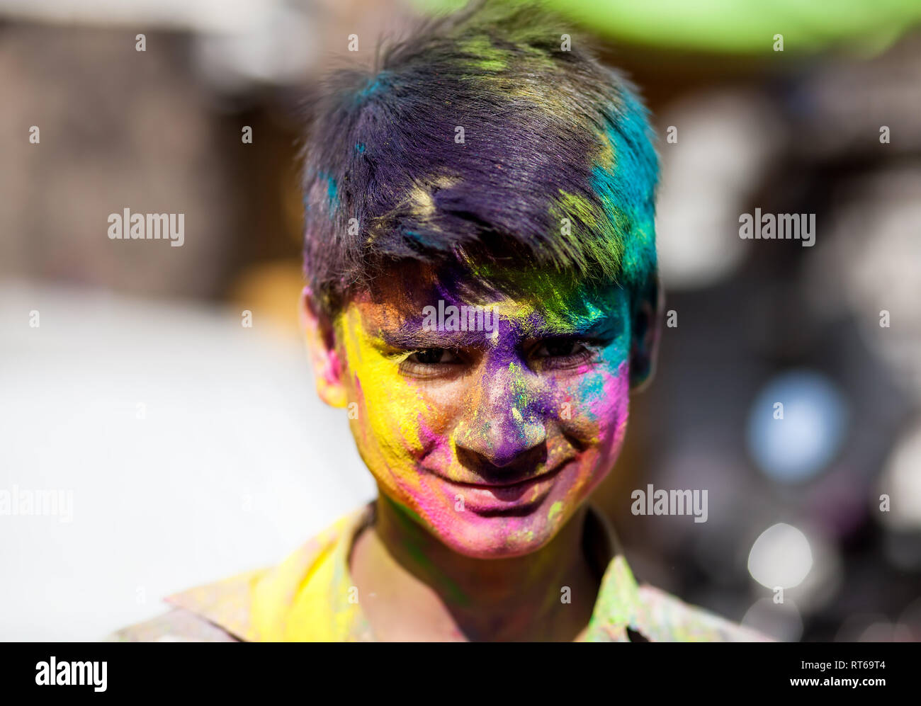 Udaipur, India - March 6, 2015: Portrait of Indian boy with painted face celebrating the colorful festival of Holi on the street. Stock Photo