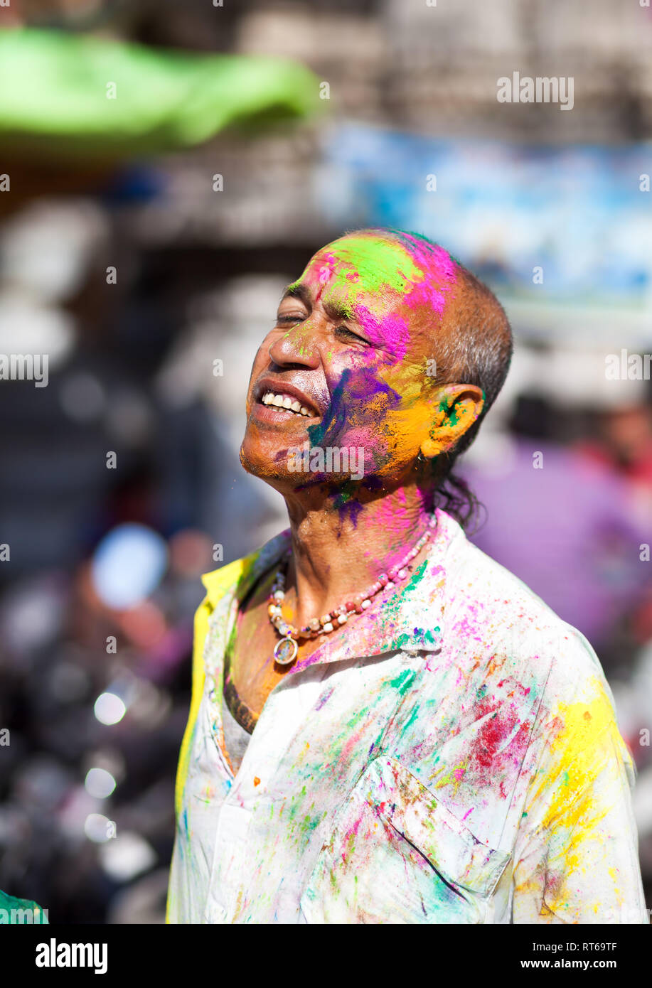 Udaipur, India - March 6, 2015: Portrait of Indian man with painted face celebrating the colorful festival of Holi on the street. Stock Photo