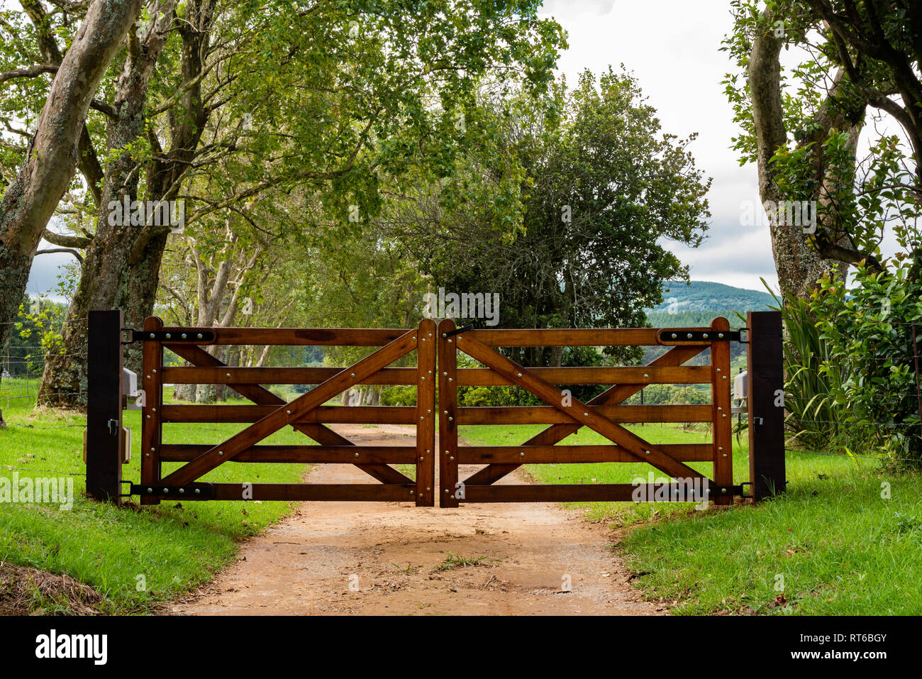 Wooden gates at the tree lined entrance to a lifestyle farm. Stock Photo