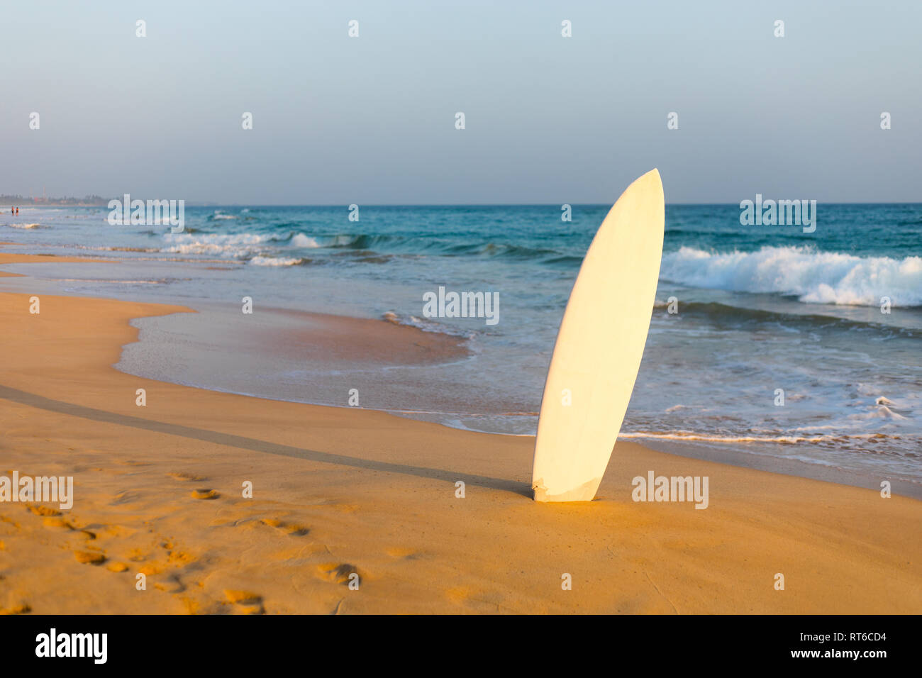 Surfboard stuck in the sand to the beach. Stock Photo