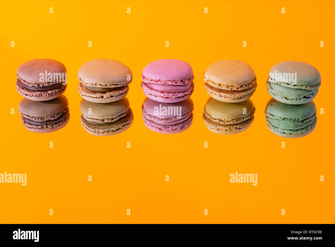 Tasty colorful macaroon homemade isolated on a mirror and a colorful background and reflections contemporary decoration Stock Photo