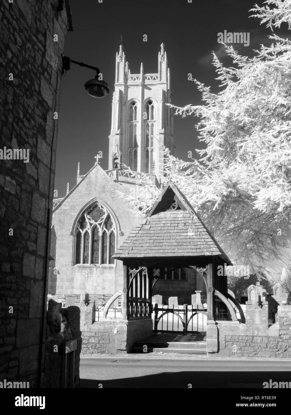 Infrared monochrome of All Saints Church and it's lychgate from Church Walk in the North Somerset village of Wrington, England. Stock Photo