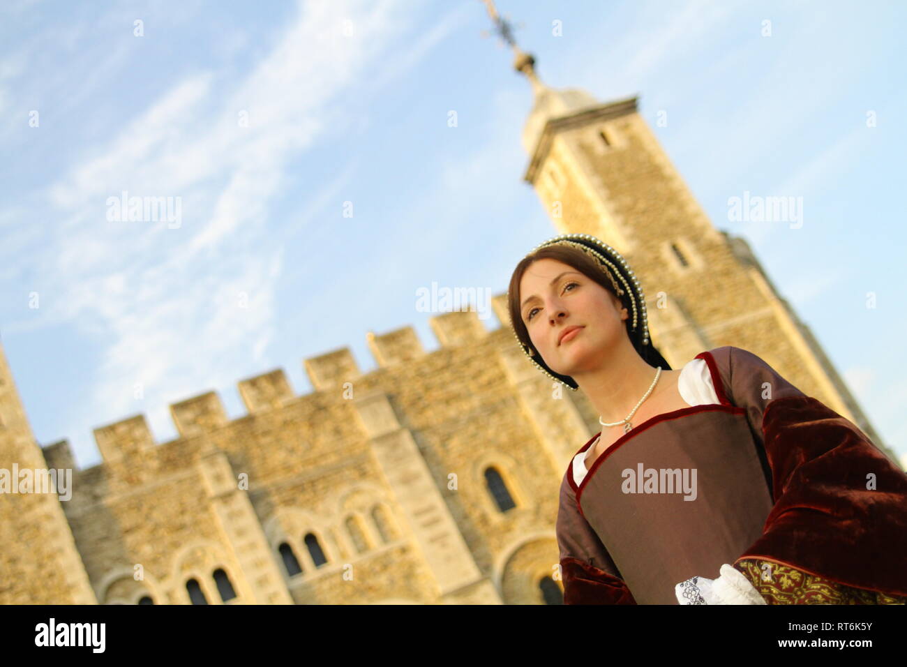 A woman dressed as Anne Boleyn stands in front of the Tower of London ...
