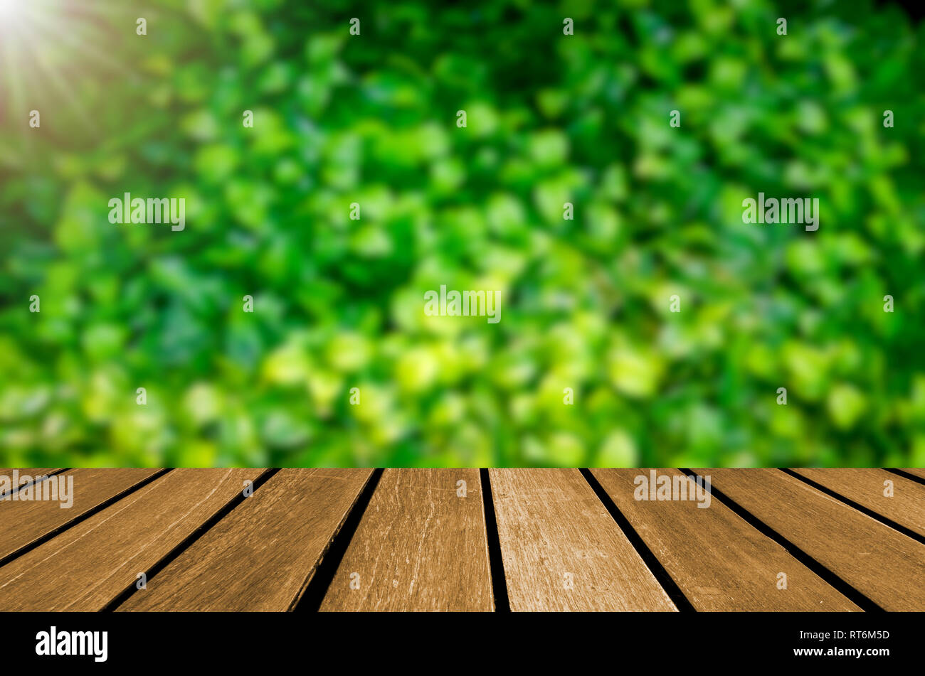 Empty wooden planks blur green leaf background. Can be used for display  Stock Photo - Alamy