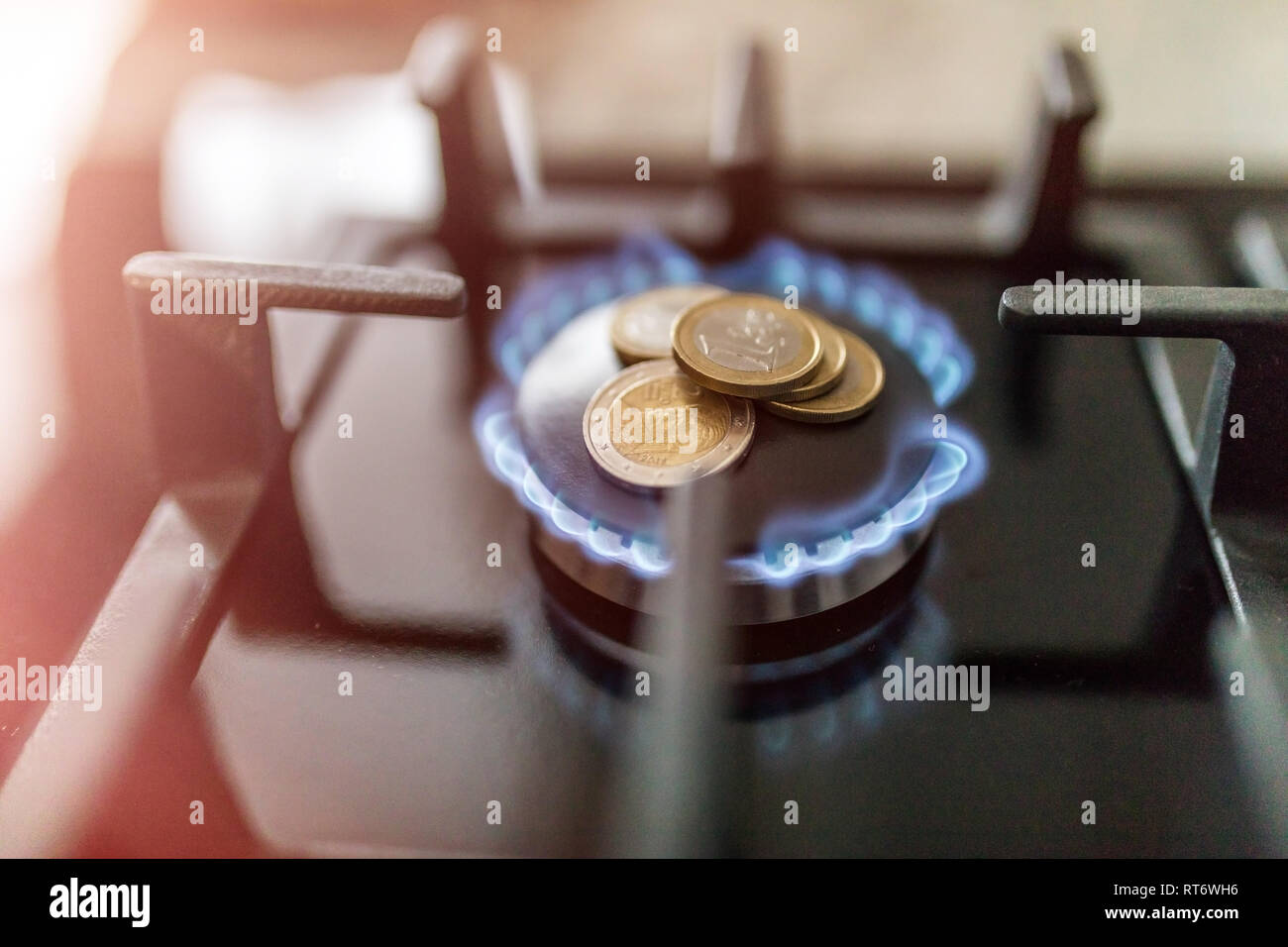 Cost of gas, concept crisis. Gas stove with coins in flame. The cost of