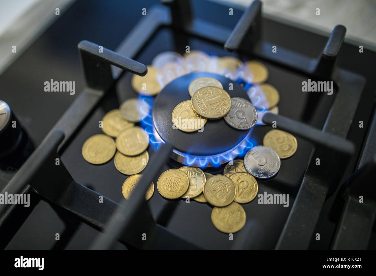 Cost of gas, concept crisis. Gas stove with coins in flame. The cost of