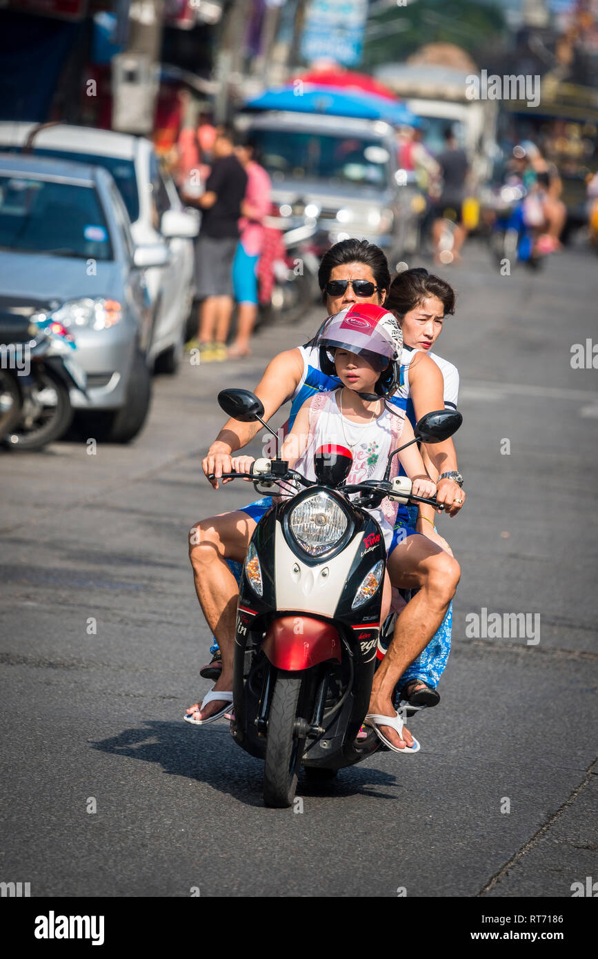 Family riding a moped along a street in Phuket, Thailand. Stock Photo