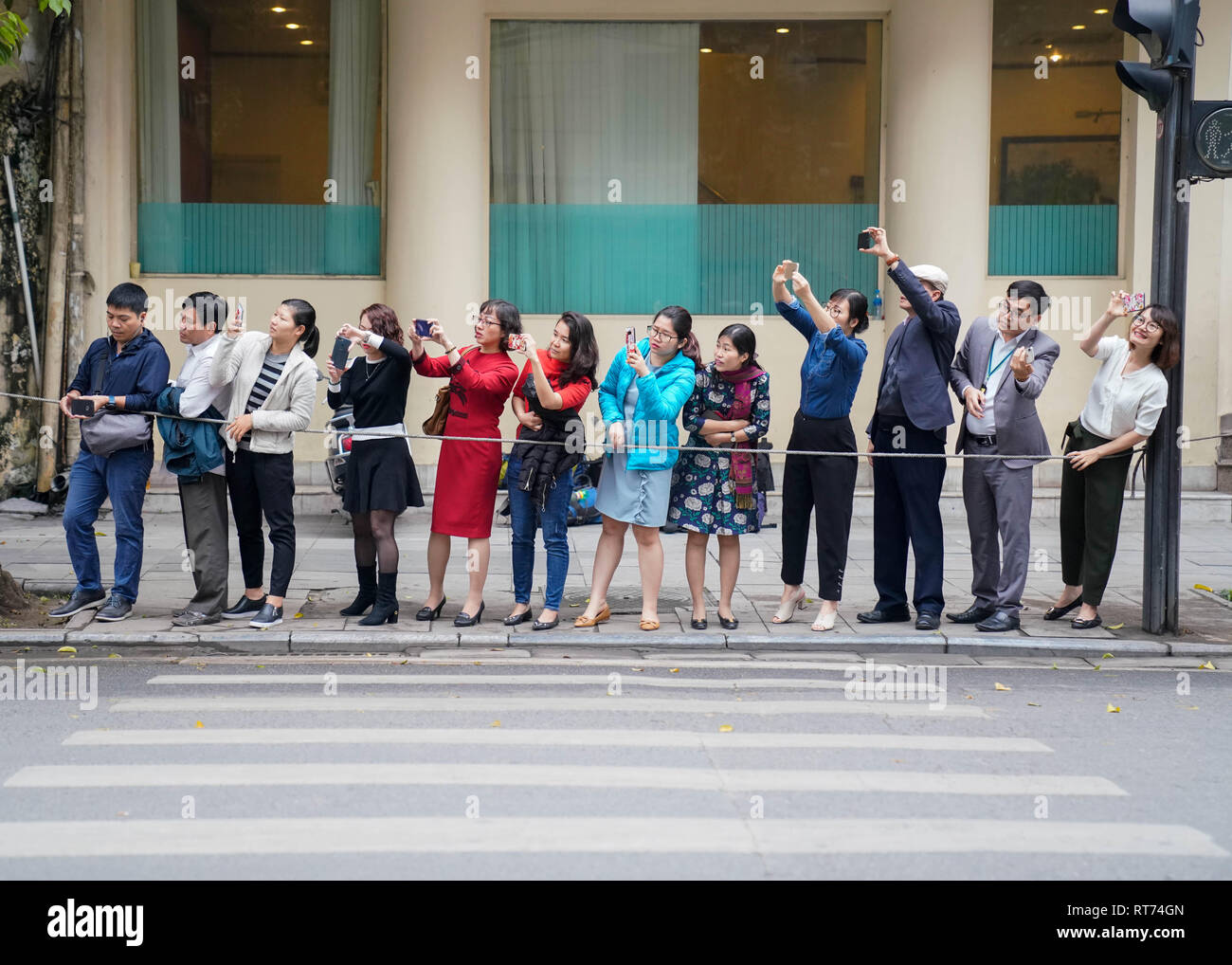 Hanoi, Vietnam. 28th Feb, 2019. February 28, 2019 - Hanoi, Vietnam - People take photos of the motorcade of U.S. President Donald Trump heading to the Sofitel Legend Metropole Hanoi where he will participate in a series of meetings during the second North Korea-U.S. Summit in the capital city of Hanoi, Vietnam. Credit: Christopher Jue/ZUMA Wire/Alamy Live News Stock Photo