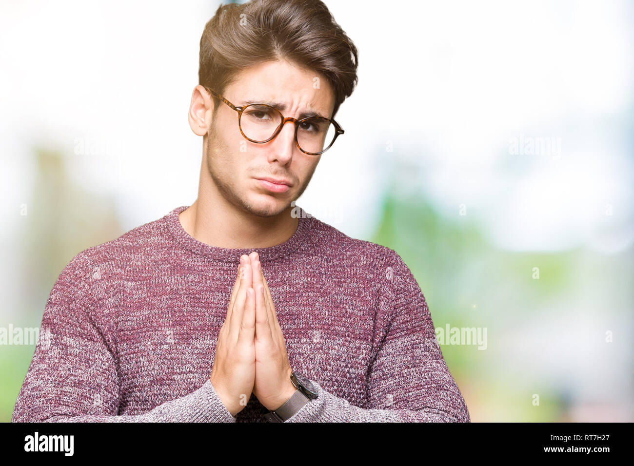 Young handsome man wearing glasses over isolated background begging and  praying with hands together with hope expression on face very emotional and  wo Stock Photo - Alamy