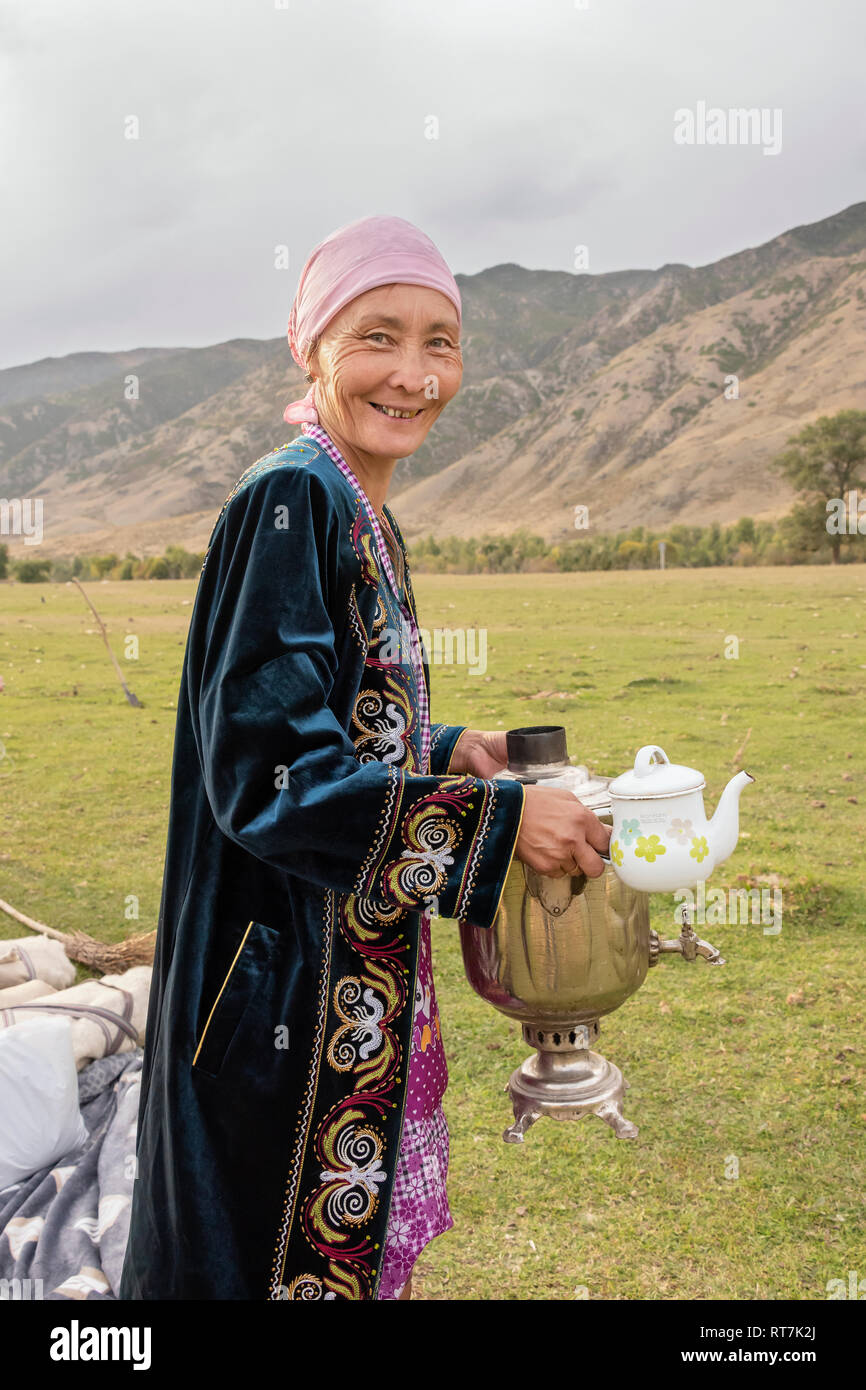 Kazakh woman carrying tube samovar and teapot at a yurt raising ceremony,  Saty, Kazakhstan Stock Photo - Alamy