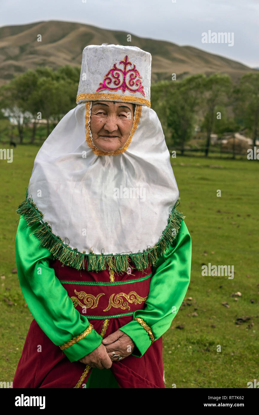 Kazakh grandmother in traditional attire at yurt raising, Saty, Kazakhstan Stock Photo