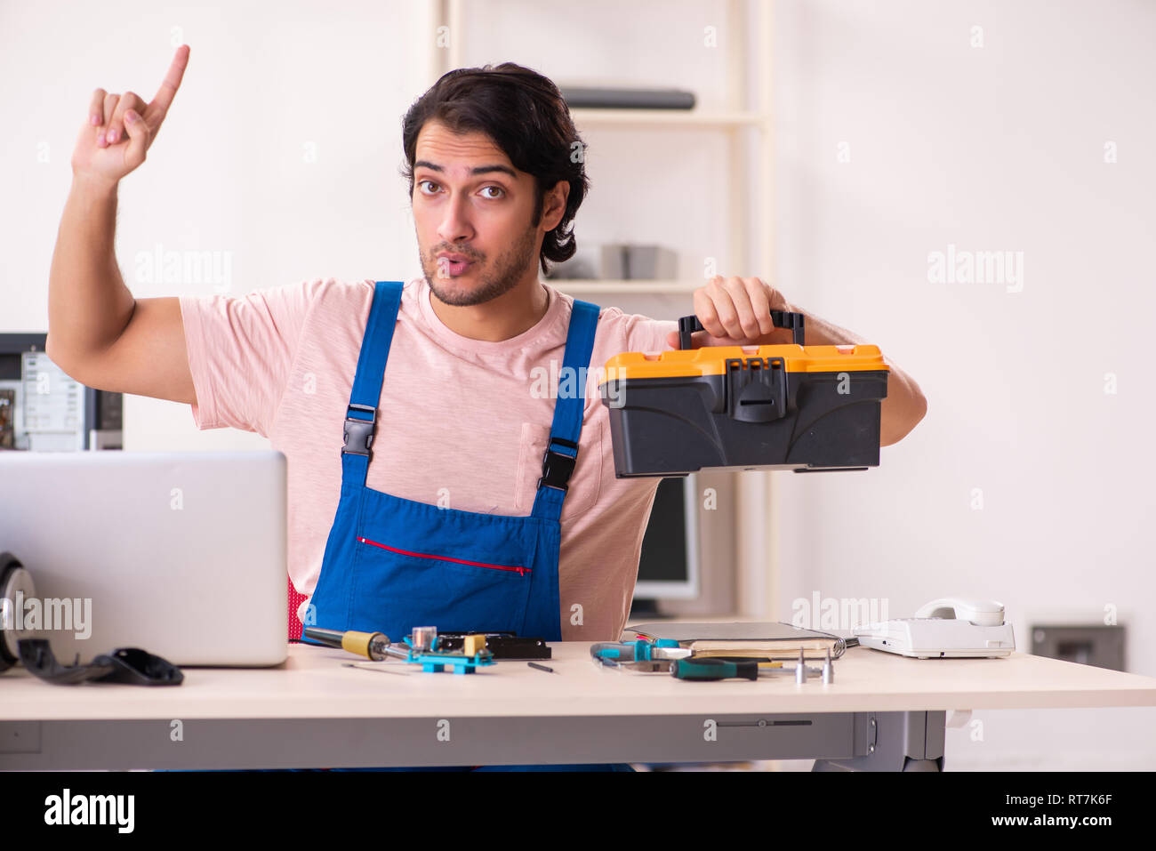 Young male contractor repairing computer Stock Photo