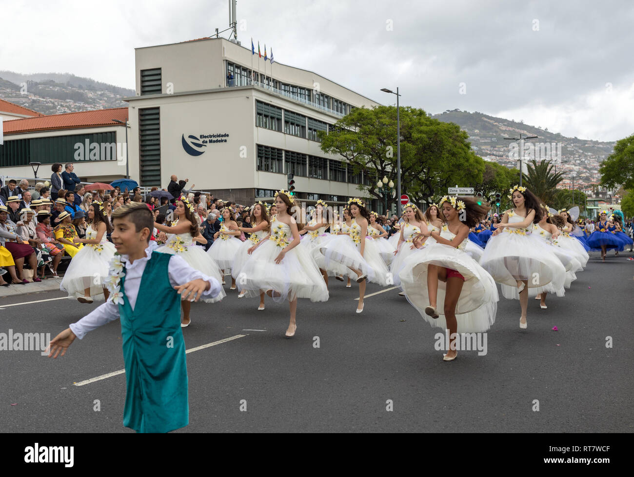 Funchal; Madeira; Portugal - April 22; 2018: A group of girls in colorful costumes are dancing at Madeira Flower Festival Parade in Funchal on the Isl Stock Photo