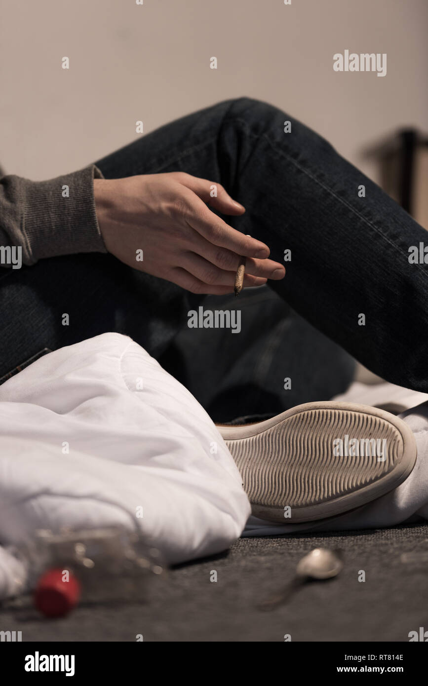 selective focus of junkie man holding rolled marijuana cigarette Stock Photo Alamy