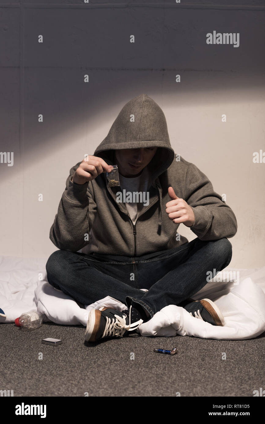 junkie man holding pack of marijuana and showing thumb up Stock Photo Alamy