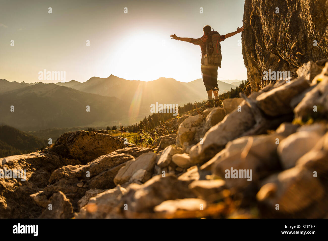 Hiking man standing in he mountains, cheering Stock Photo