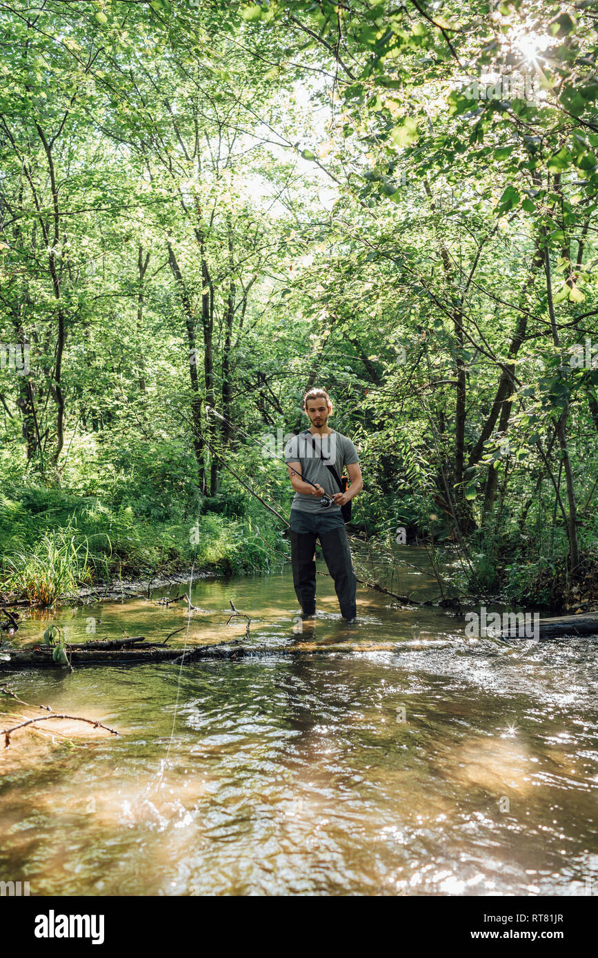 Young man fishing in a forest Stock Photo
