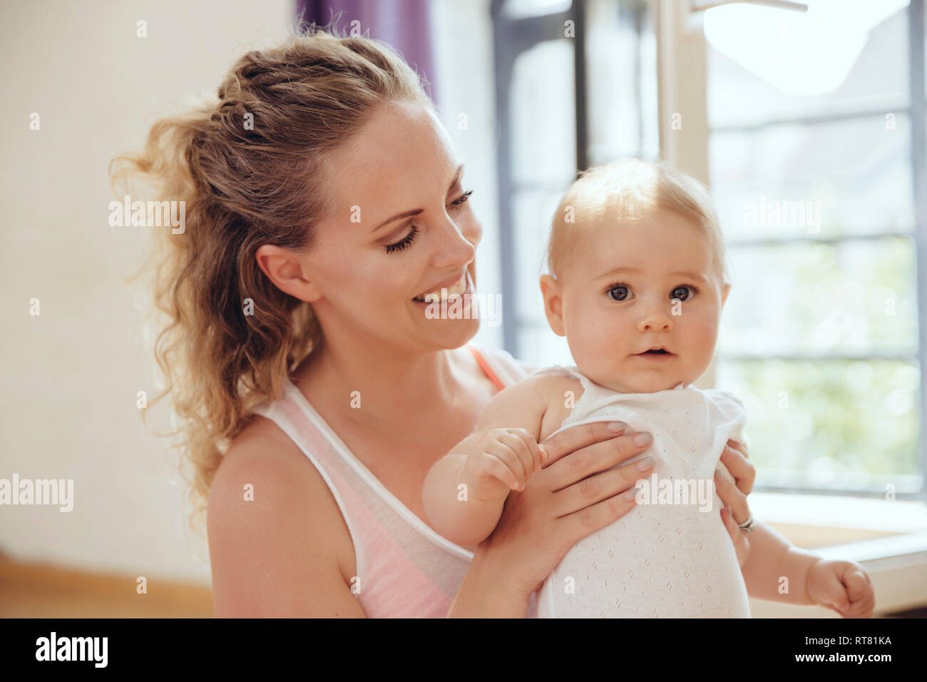Smiling mother holding her baby Stock Photo