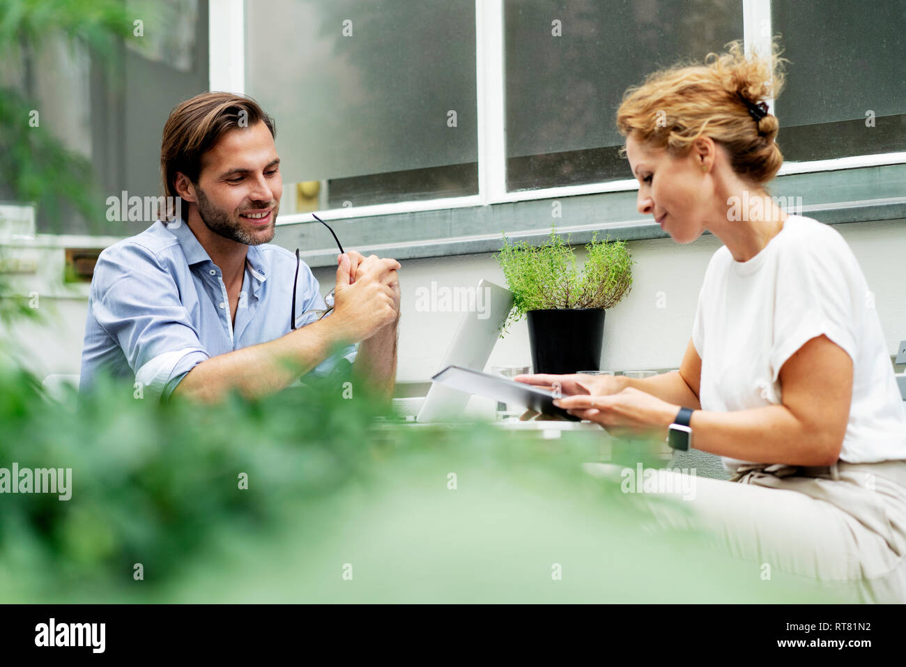 Happy couple working from home, sitting in their garden Stock Photo