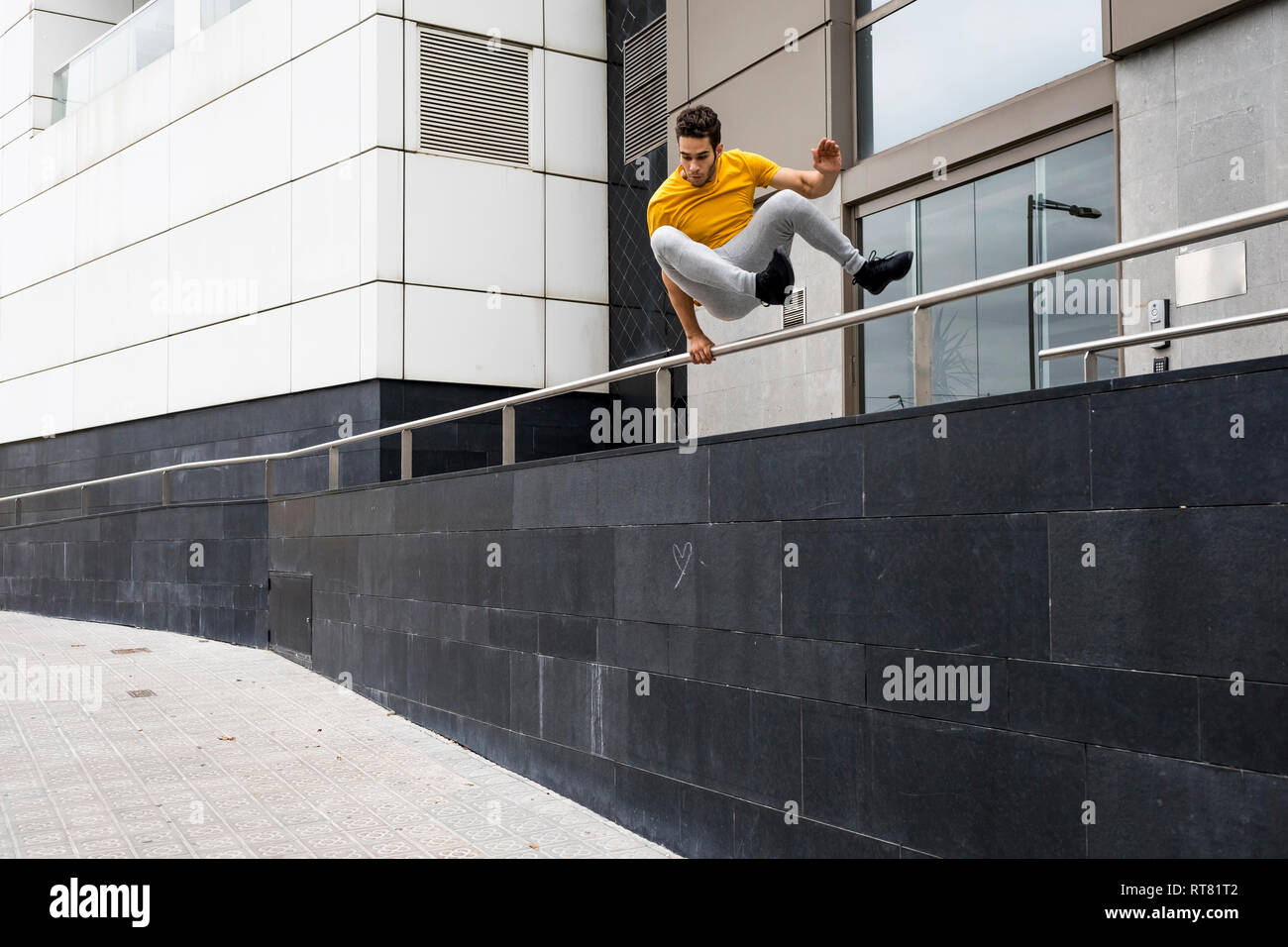 Young man jumping over railing Stock Photo Alamy