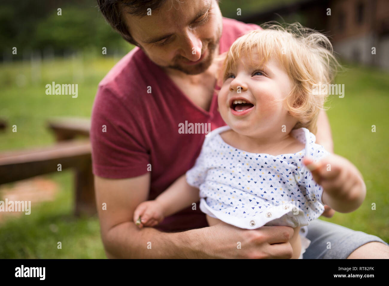 Father dressing his little son in the garden Stock Photo