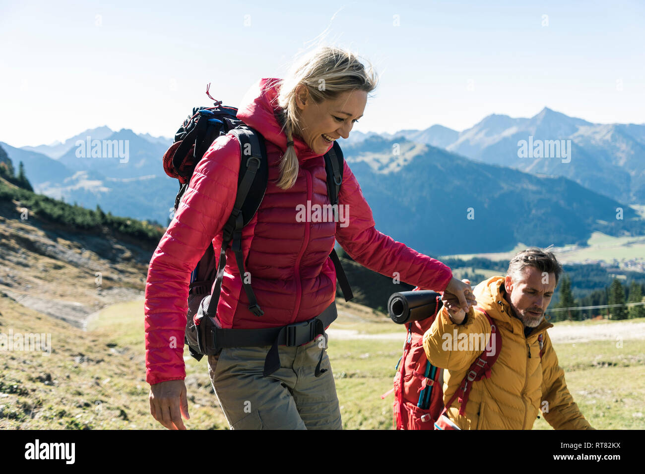 Austria, Tyrol, smiling couple hiking hand in hand in the mountains Stock Photo
