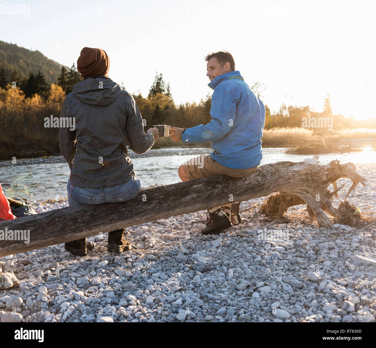 Mature couple camping at riverside in the evening light Stock Photo