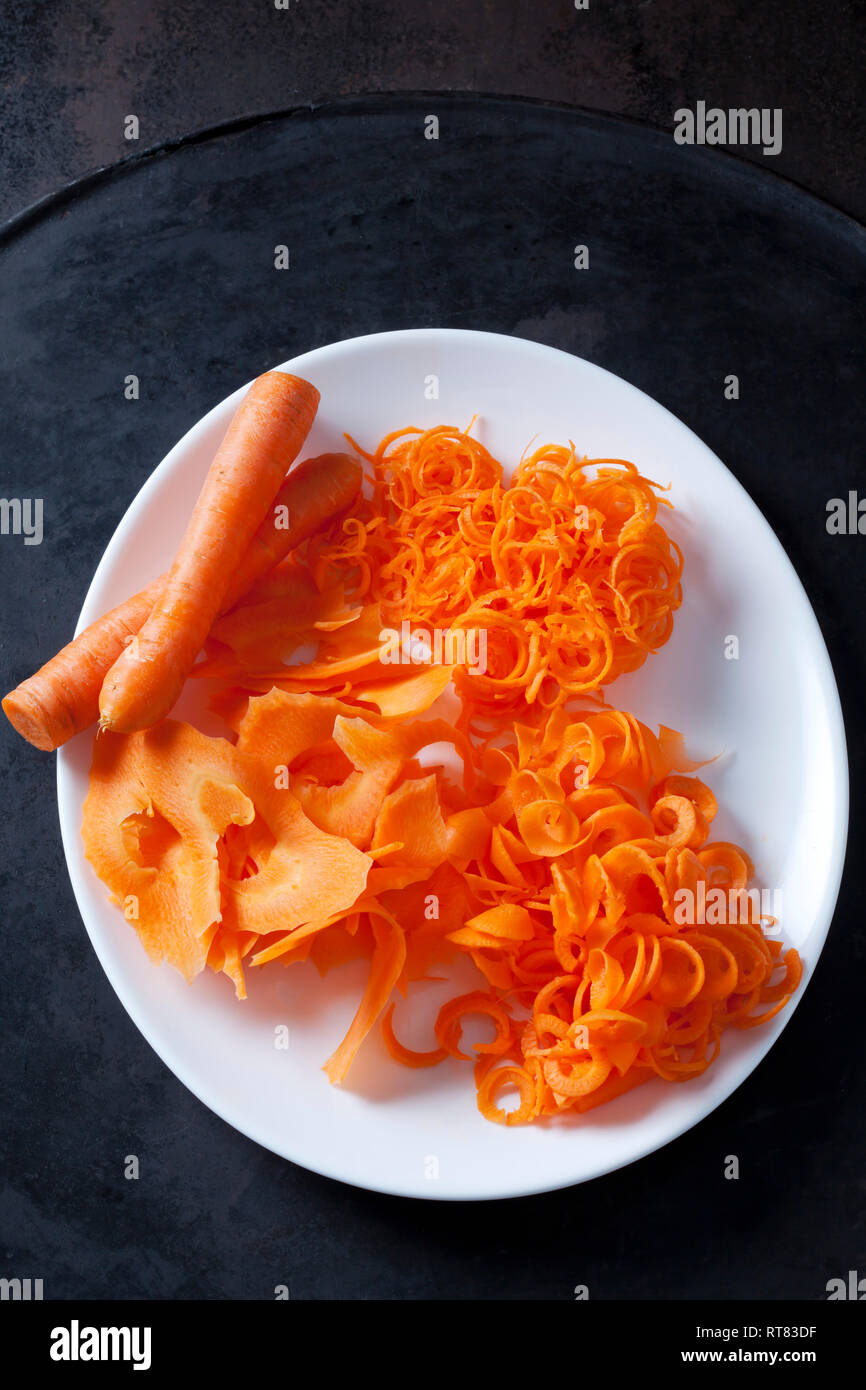 Whole and spiralized carrots on plate Stock Photo