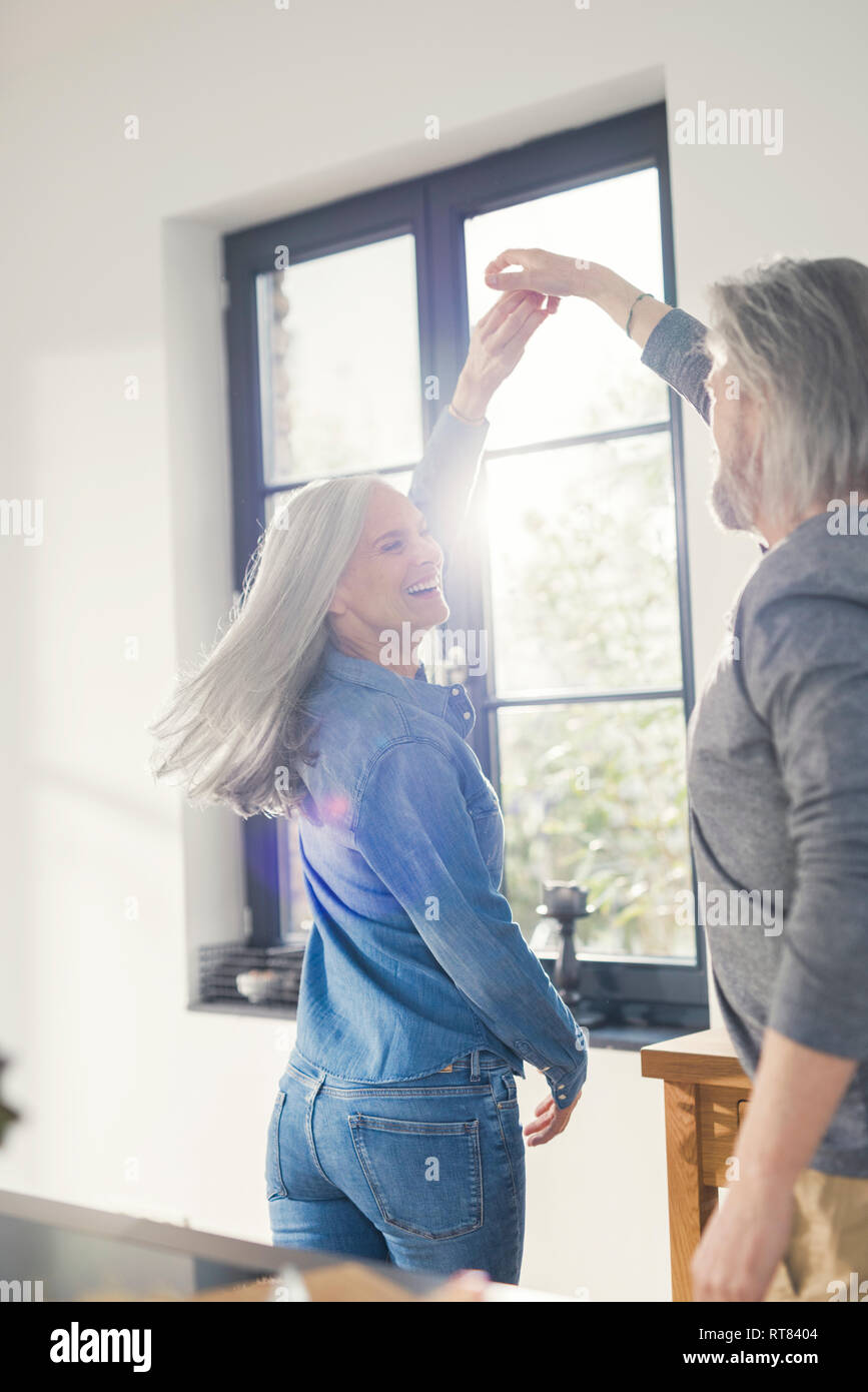 Youthful senior couple dancing in the kitchen Stock Photo
