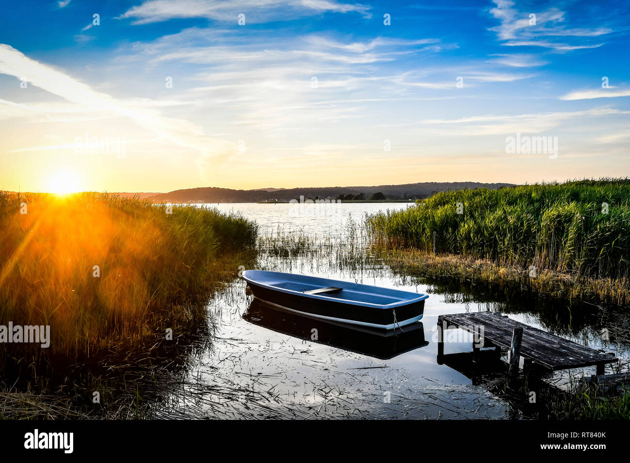 Germany, Mecklenburg-Western Pomerania, Ruegen, Sellin, empty rowing boat near jetty at sunset Stock Photo