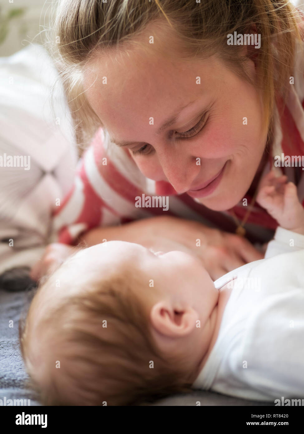 Smiling mother atching her baby daughter Stock Photo