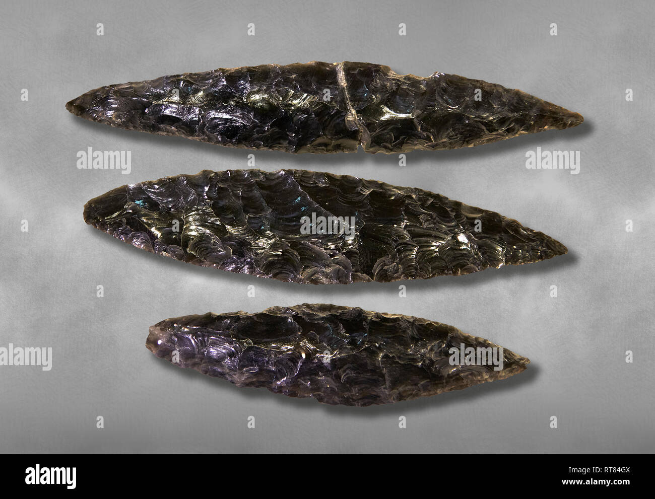 Black obsidian blades. Catalhoyuk Collections. Museum of Anatolian Civilisations, Ankara. Against a gray mottled background Stock Photo