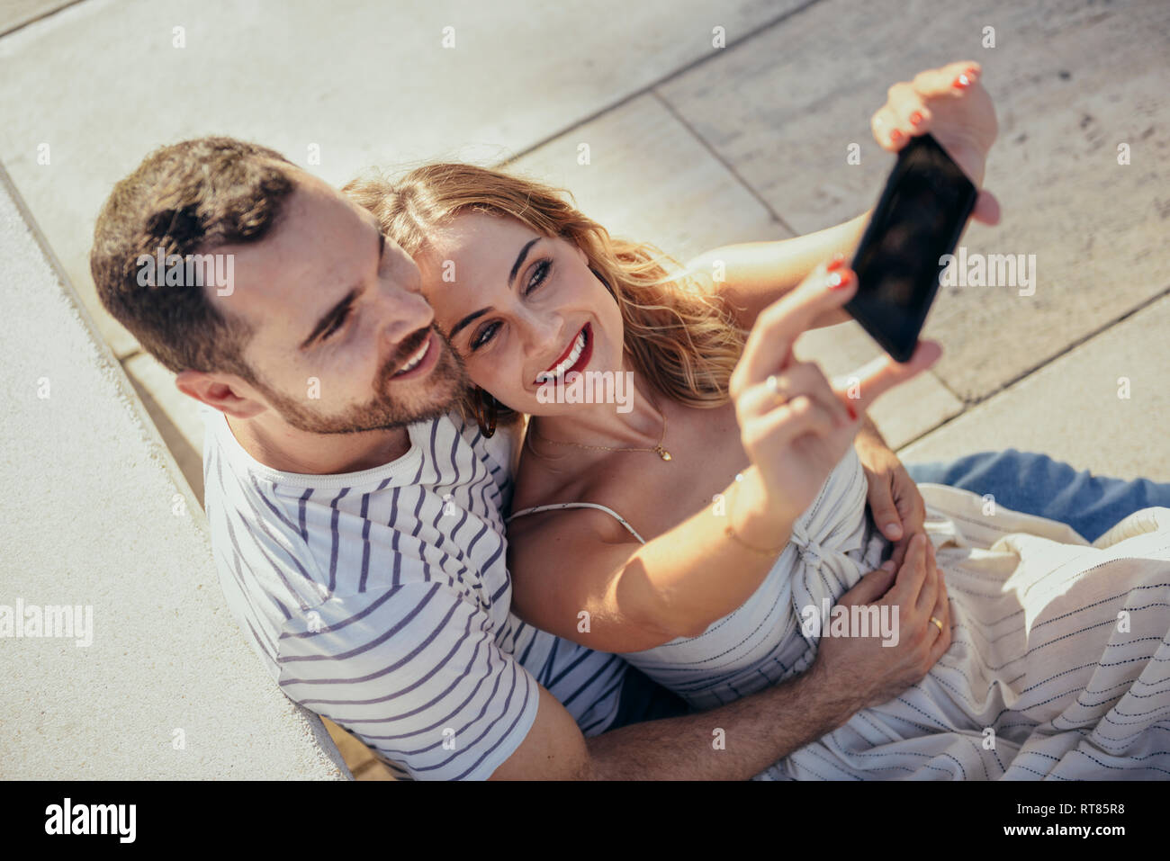 Smiling couple taking selfie with smartphone Stock Photo