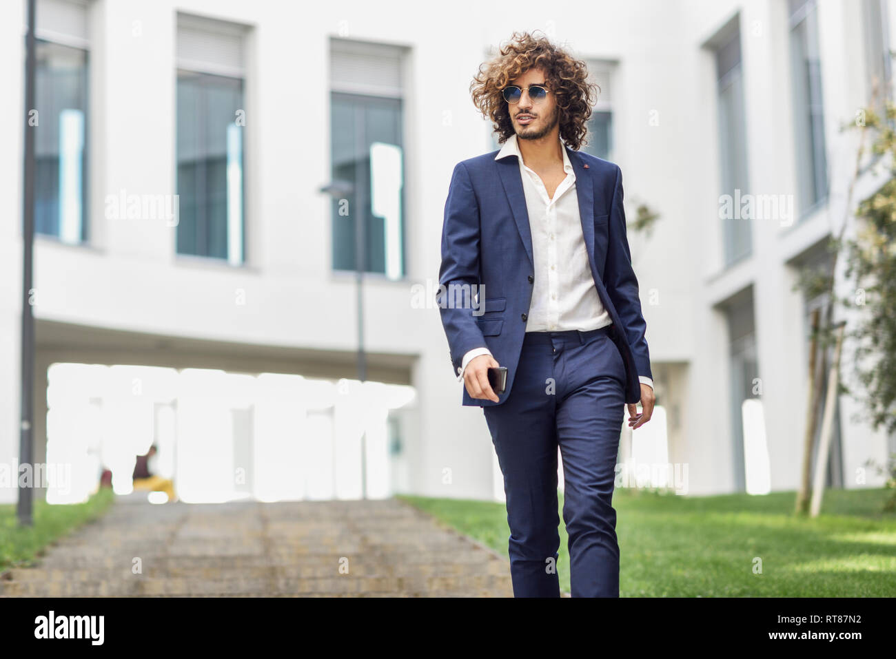 Portrait of young fashionable businessman with curly hair wearing blue suit and sunglasses Stock Photo - Alamy Portrait of young fashionable businessman with curly hair wearing blue suit and sunglasses Stock Photo - Alamy