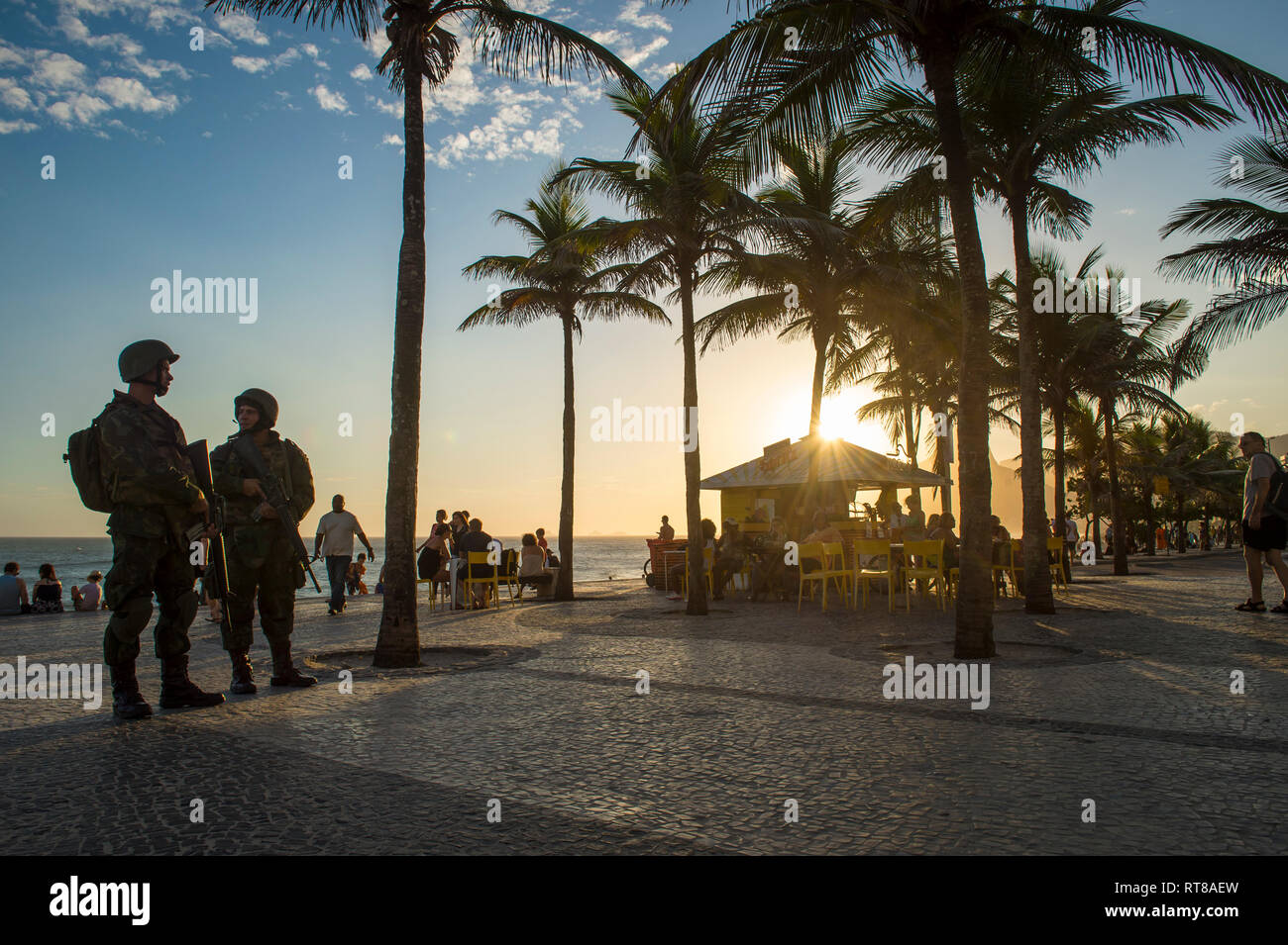 RIO DE JANEIRO - FEBRUARY 10, 2017: Two Brazilian Army soldiers stand in full camouflage uniform on the Arpoador boardwalk at Ipanema Beach. Stock Photo