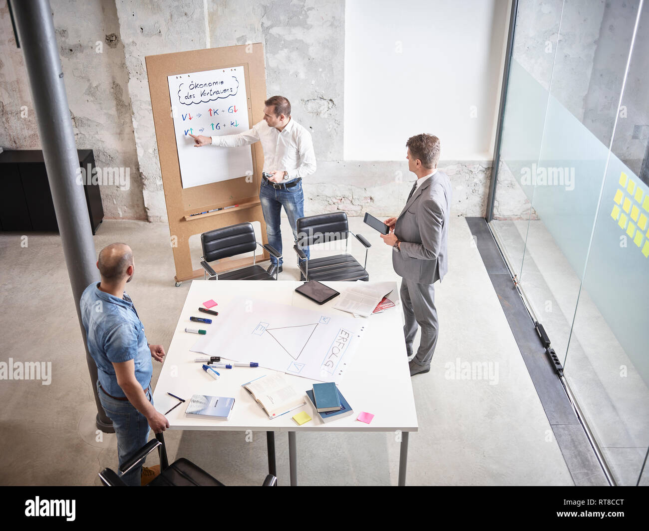 Three businessmen having a meeting with flipchart in conference room Stock Photo