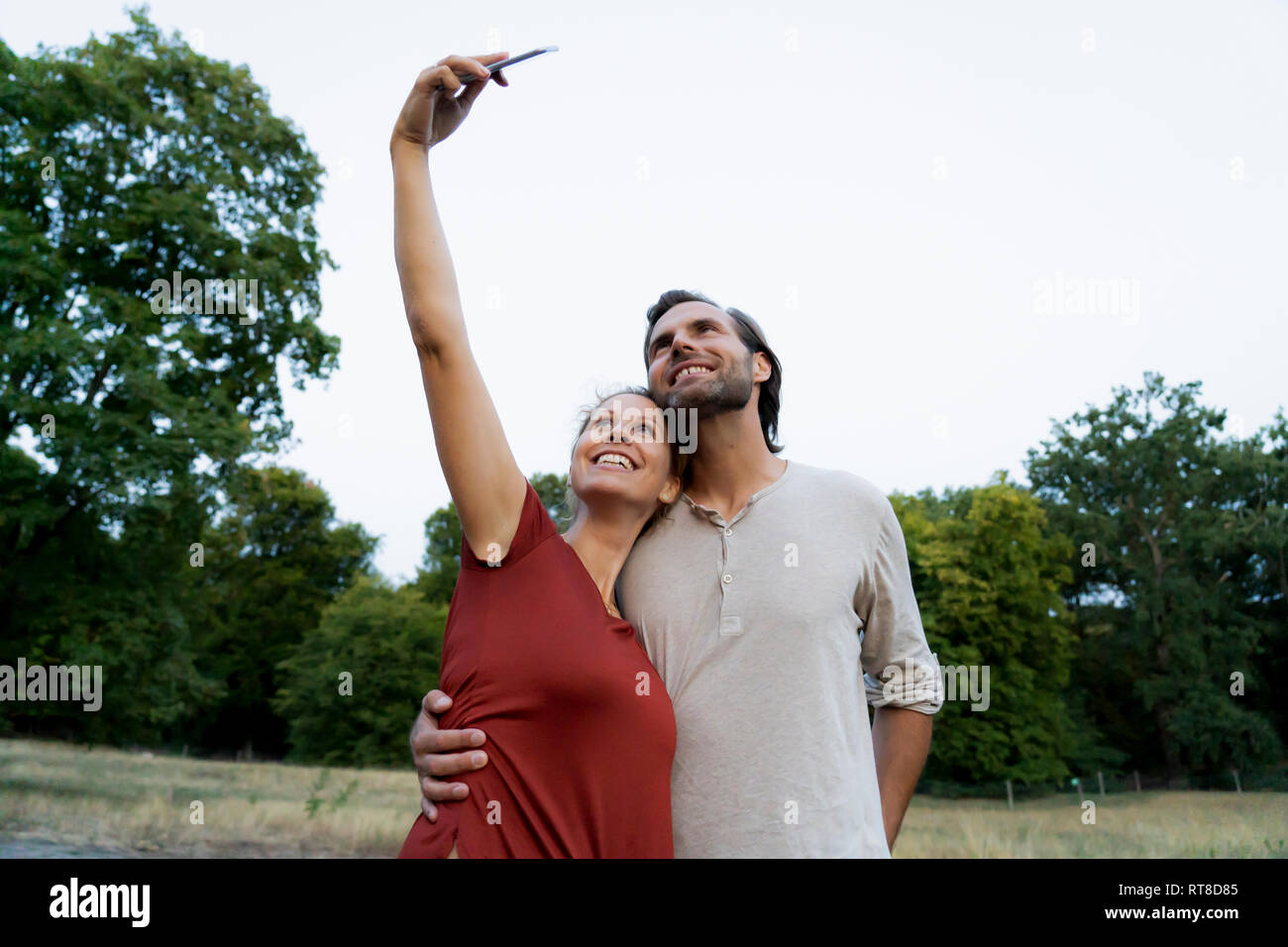 Happy couple taking selfies outdoors Stock Photo